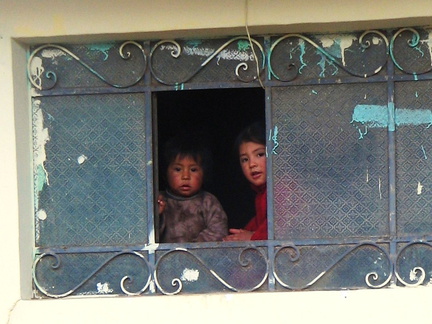 IMG 4197 Kindertjes kijken vanuit hun raam naar ons in de bus